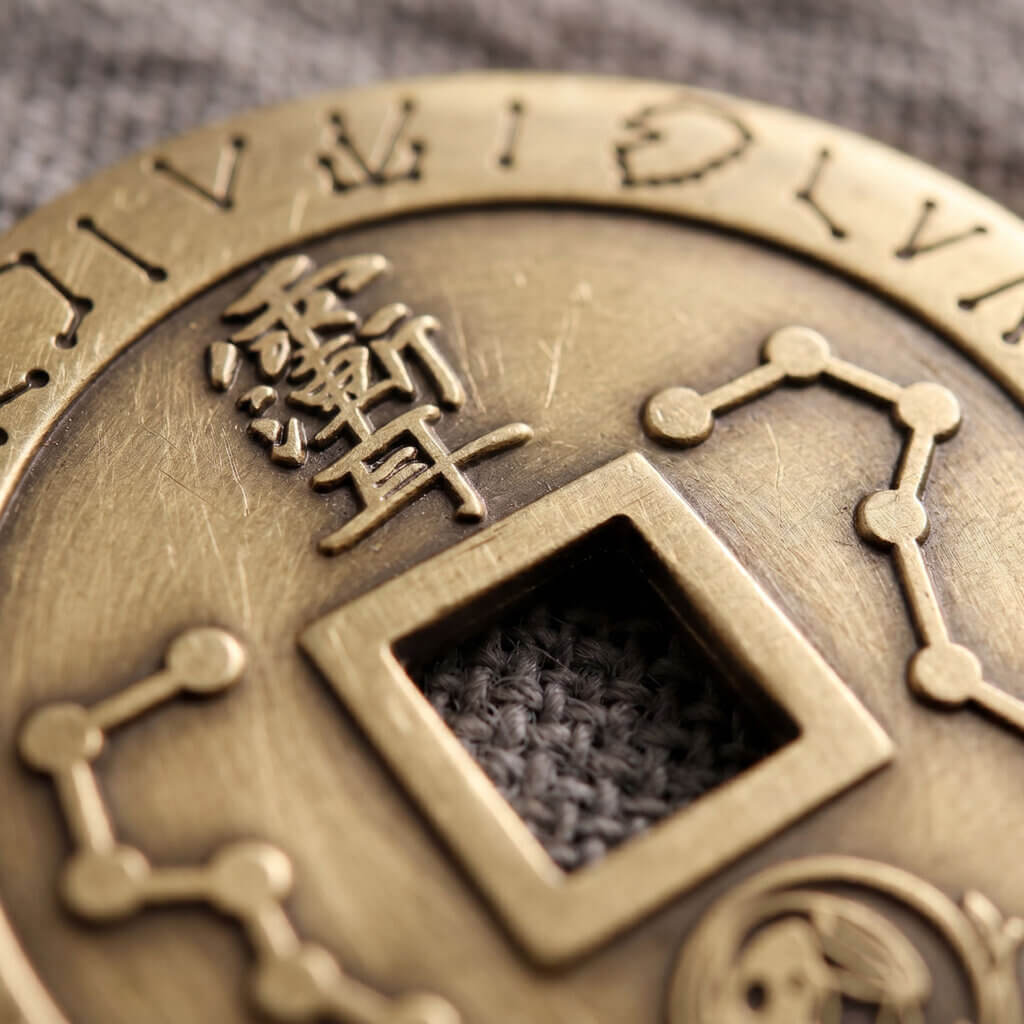 Close-up engraving of Ziwei motif and star symbols on brass coin pendant